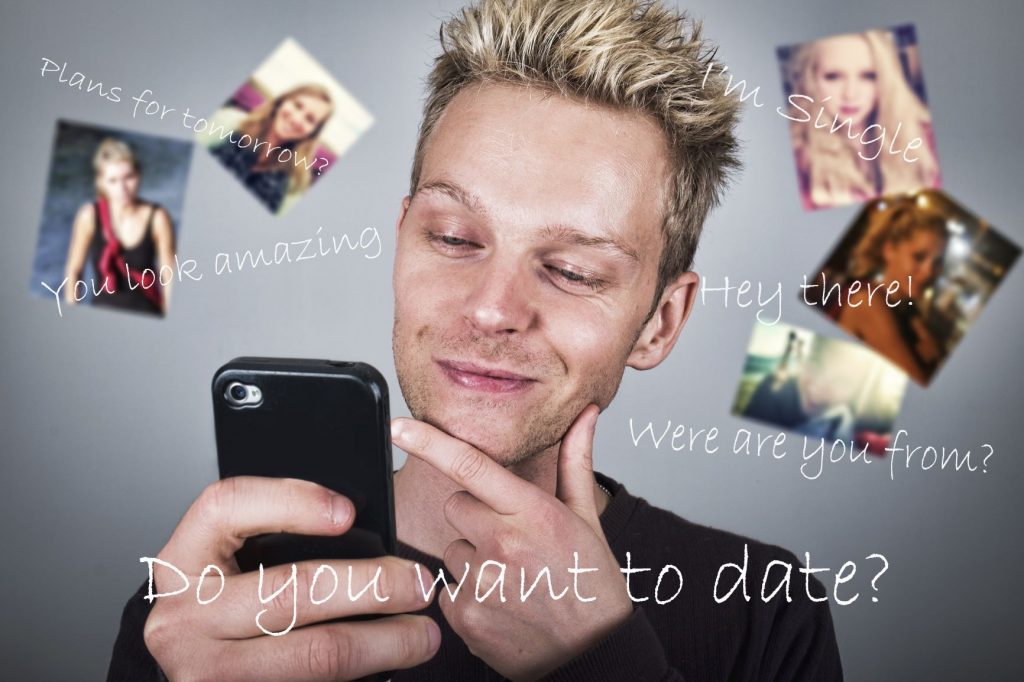 A young man considers his dating options viewing pictures of young women on his spartphone.